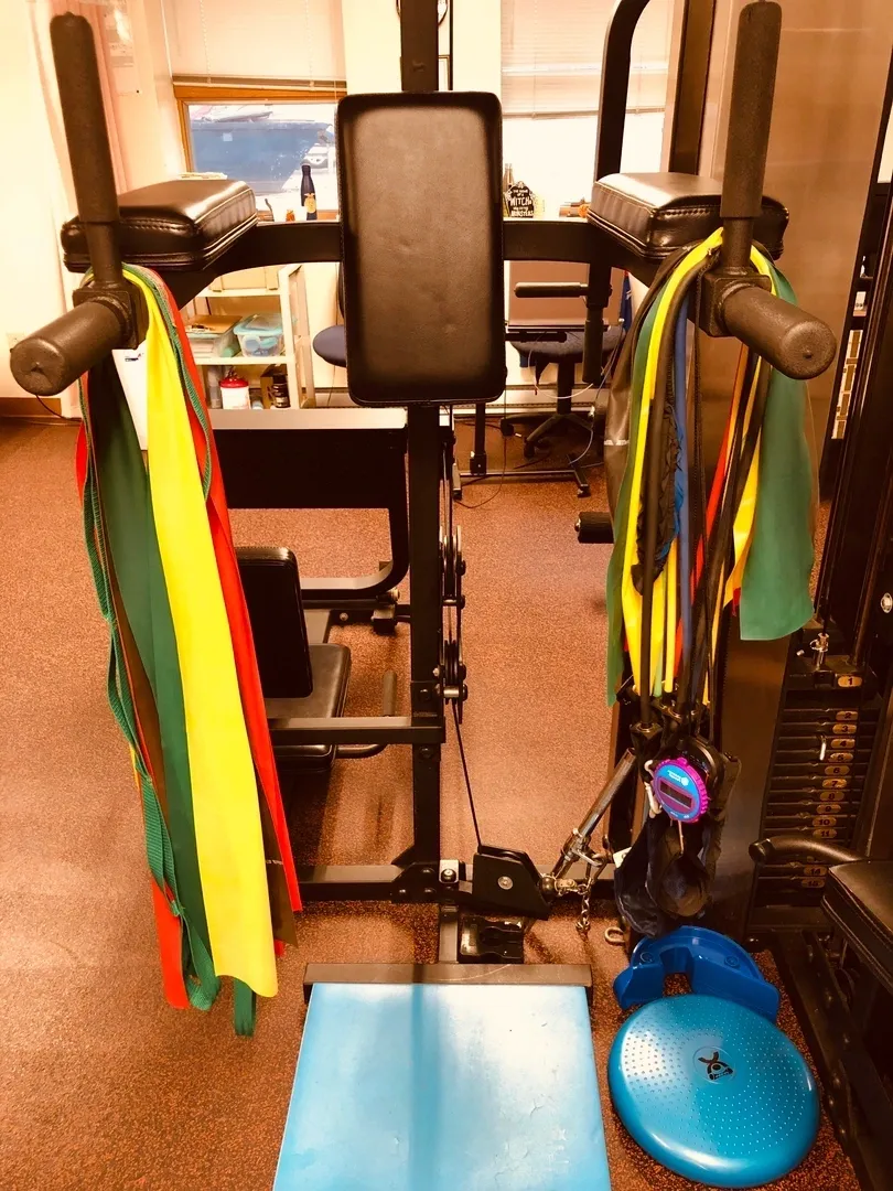 A gym with many different colored ties hanging from it.