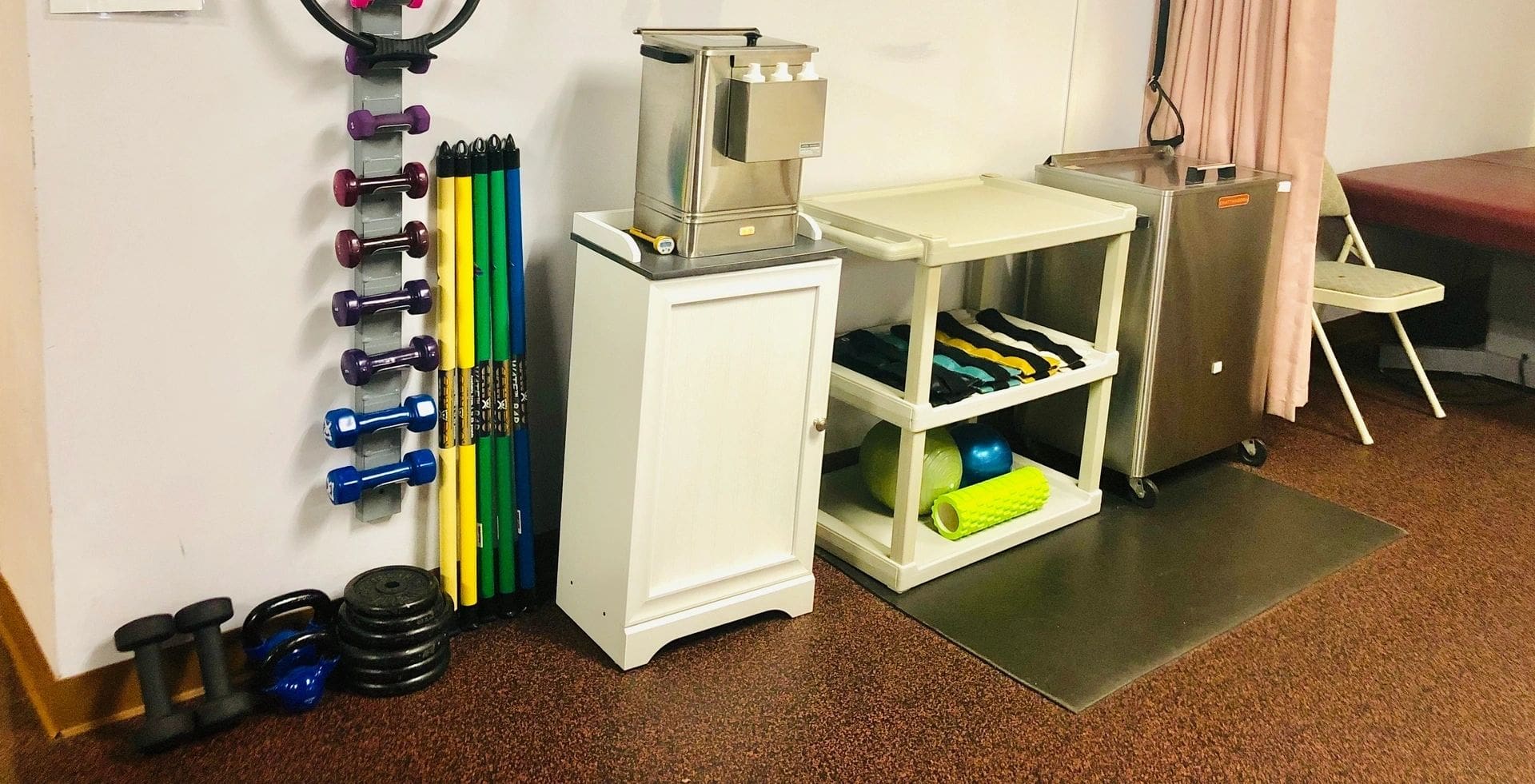 A white cabinet next to some gym equipment.